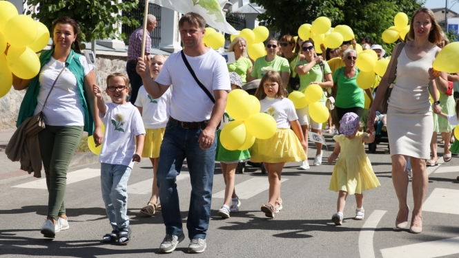 Daudz cilvēku ar baloniem rokās piedalās gājienā Krāslavā